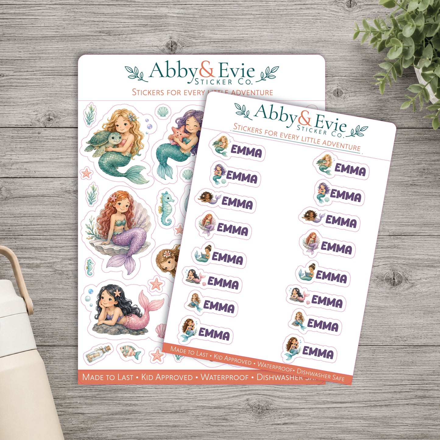 Two sticker sheets from Abby & Evie Sticker Co. displayed on a gray wood background.