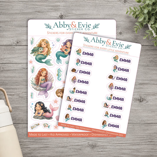 Two sticker sheets from Abby & Evie Sticker Co. displayed on a gray wood background.