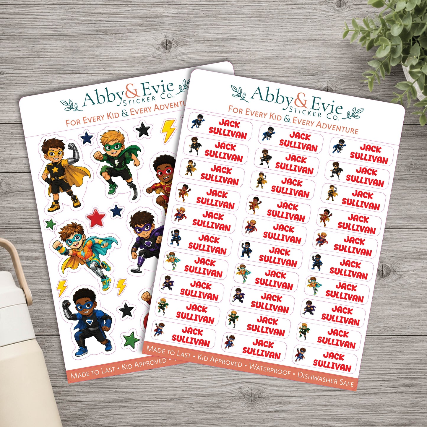 Two sticker sheets from Abby & Evie Sticker Co. featuring cartoon children and the name 'Jack Sullivnan' repeated across the sheets, styled on a gray wood surface with a book corner and greenery.
