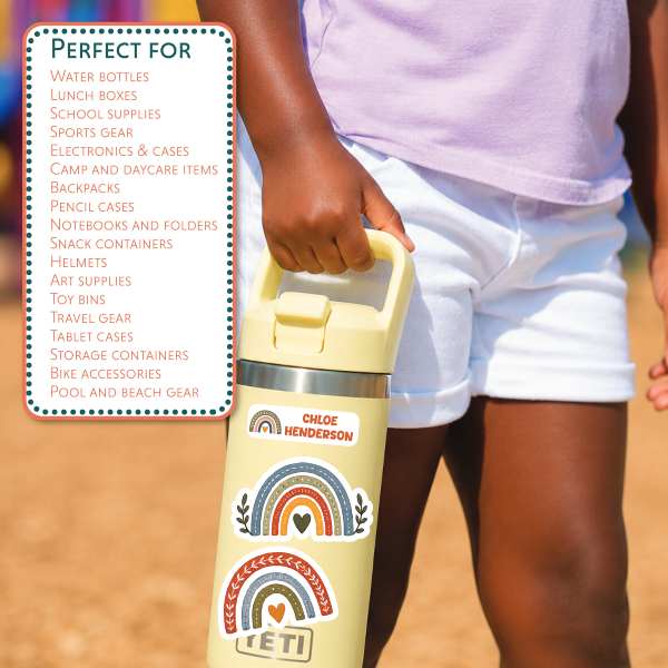 A person outdoors holding a pale yellow insulated bottle with rainbow and heart decals. A white text box on the left lists bottle types the bottle is suitable for, including water bottles, lunch boxes, school supplies, sports gear, backpacks, and more.