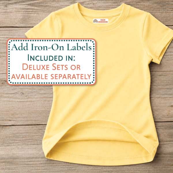 A pale yellow short-sleeve t-shirt laid flat on a rustic wooden surface, with an informational text box overlaid on the left side about iron-on labels.